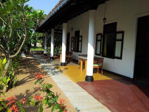 a patio of a house with a table and chairs at The Danish Villa Resort in Arugam Bay