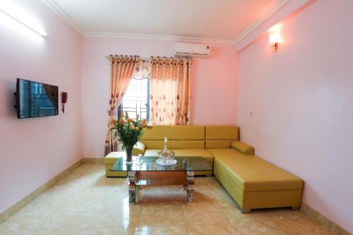 a living room with a couch and a table at Khách Sạn Bình An in Sóc Sơn