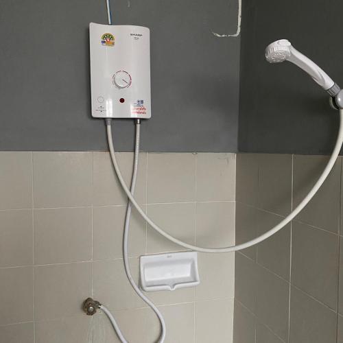 a shower with a hose attached to a wall at Saran Hotel krabi Thailand in Krabi
