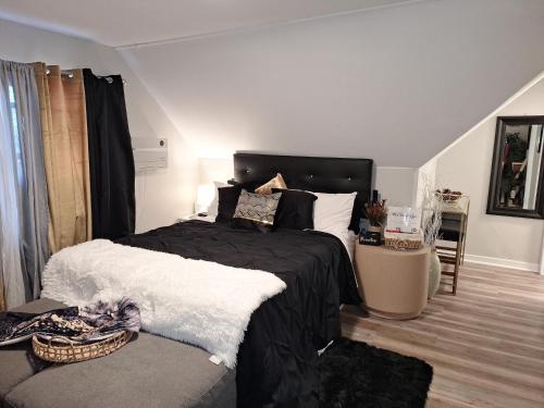 a bedroom with a black and white bed and a couch at St Paul Fry Street Den Tower Suite #3 in Saint Paul
