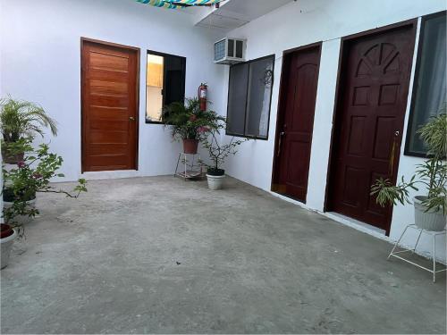 a room with two doors and potted plants at GJES Lodge AND GUESTHOUSE in Moalboal