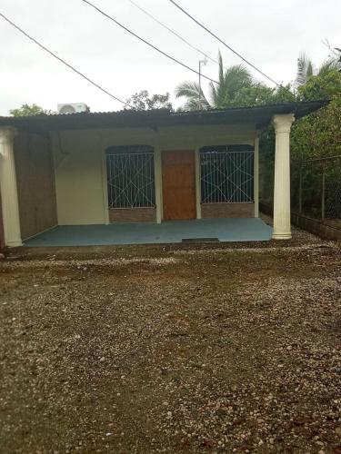 a small house with a porch and a pillar at Casa Tabacon cr in Río Claro
