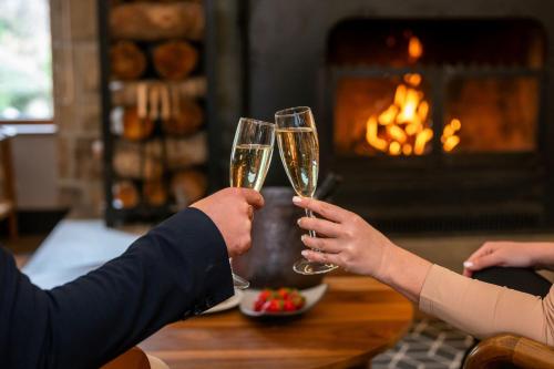 two people holding champagne glasses in front of a fireplace at Four Points by Sheraton Bansko in Bansko