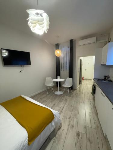 Un dormitorio con una cama y una mesa y una cocina. en Gabriela Studio Central, en Satu Mare