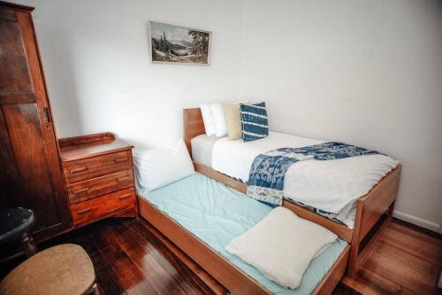a small bedroom with a bed and a dresser at Craypot Cottage in Port Campbell