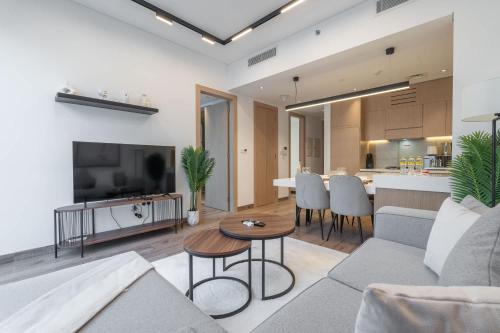 a living room with a couch and a table at Free housekeeping visits during your stay - StayShort - Stylish, Minimalist 2-Bedroom in Jumeirah Village Circle in Dubai