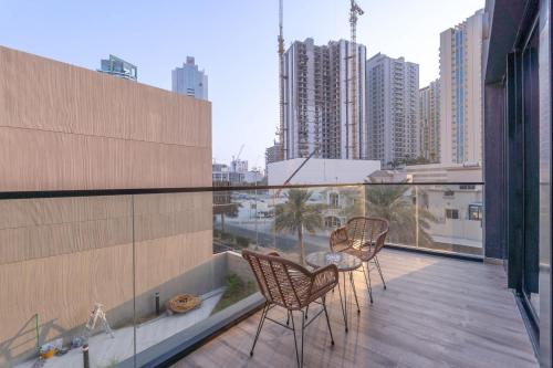 a balcony with two chairs and a table on a building at Free housekeeping visits during your stay - StayShort - Stylish, Minimalist 2-Bedroom in Jumeirah Village Circle in Dubai