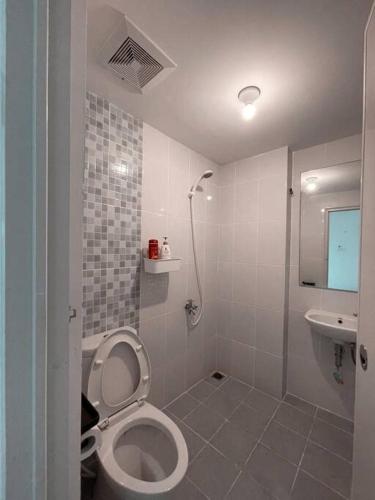 a white bathroom with a toilet and a sink at Bangulbobo 2br tower Ishikawa in Sungaitahang
