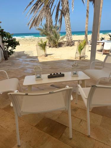 a table and chairs with the beach in the background at Villa Nº 25 Alfredo Marchetti Suites on the Beach,Praia de Chaves BV in Cabeçadas