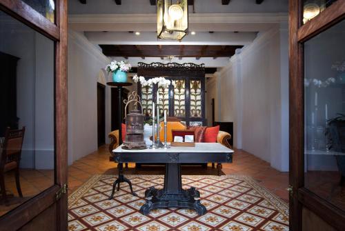 a living room with a table and a couch at Jawi Peranakan Mansion in George Town