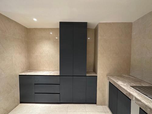 a kitchen with black cabinets and a counter top at Foy's Lake Resort in Chittagong