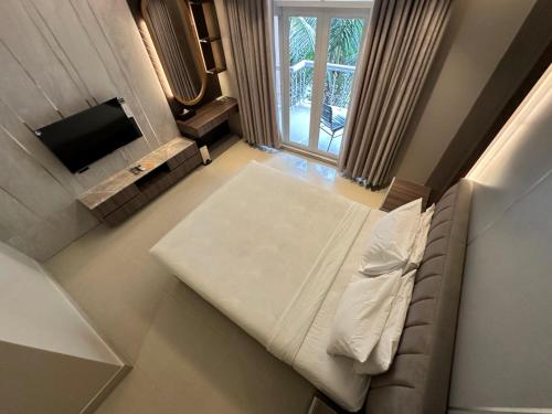 a bedroom with a large bed and a television at Foy's Lake Resort in Chittagong