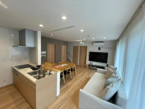 a kitchen and a living room with a couch and a sink at Niseko STREAM Villas in Rankoshi