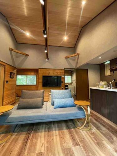 a living room with a blue couch in a room at Villa Tocca北軽井沢ヴィラ トッカ in Kita-karuizawa