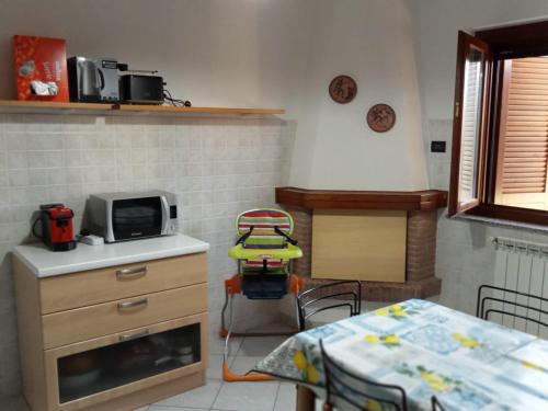 a kitchen with a table and a microwave and a chair at Alloggio turistico IL SOLE in Sutri