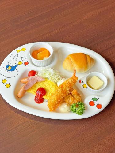 a plate of food with fish and vegetables and a sandwich at Hotel Sunshine in Engaru