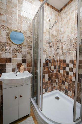 a bathroom with a shower and a sink and a tub at Kulautuva Park Apartments in Kulautuva