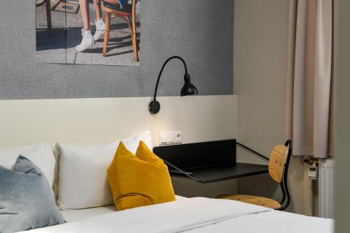 a bedroom with a bed with a laptop on a desk at SleepinRoomz Boutique Hotel in Dortmund