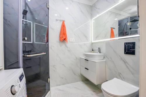 a bathroom with a shower and a toilet and a sink at Coco Chanel Apartment in Bishkek in Bishkek