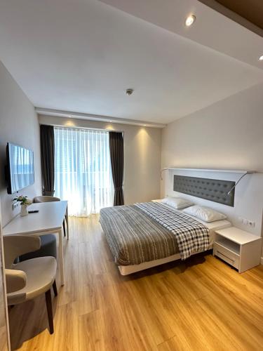a hotel room with a bed and a desk and a desk at Alliance palace 18 floor in Batumi