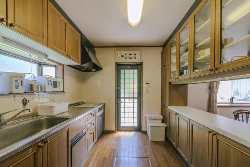 eine Küche mit Holzschränken und einer Spüle in der Unterkunft LakeView-Rental Villa Engawa House in Fujikawaguchiko