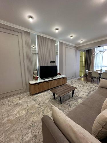 a living room with a couch and a television at Coco Chanel Apartment in Bishkek in Bishkek