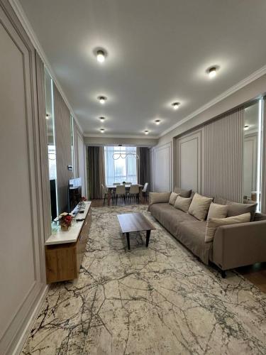 a living room with a couch and a table at Coco Chanel Apartment in Bishkek in Bishkek