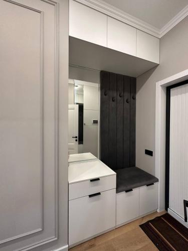 a white bathroom with a sink and a mirror at Coco Chanel Apartment in Bishkek in Bishkek