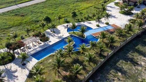 widok z góry na basen z palmami w obiekcie Casa dos sonhos, luxo em condominio à beira mar de Jacumã w mieście Jacumã