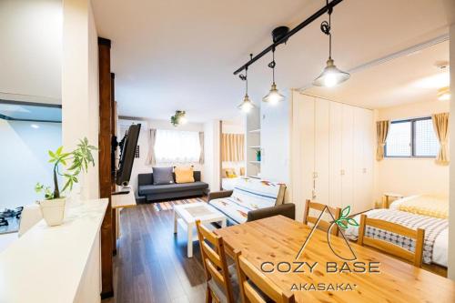 a living room with a table and a bedroom at Cozy Base Akasaka in Fukuoka