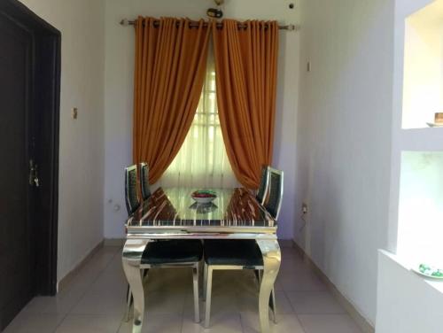 a dining room with a glass table and chairs at 2 Bed-Sleeps 4-Free Parking-AirCon-3 in Benin City