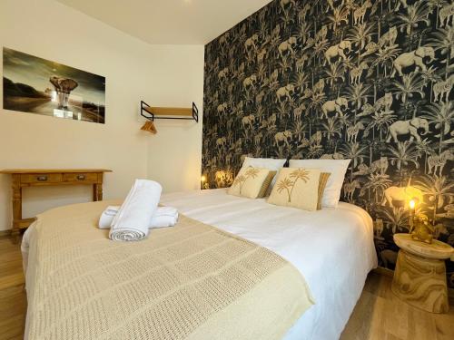 - une chambre avec un grand lit et du papier peint noir et blanc dans l'établissement L'écrin - Central - King bed - Calme - Luxe, à Arras
