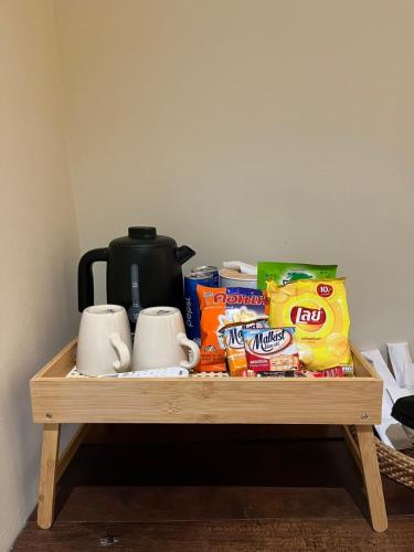 a wooden shelf with coffee cups and snacks on it at คืนโฮม เลขที่ 6 โฮมเสตย์ Kuenhome no 6 Homestay in Nam Nao