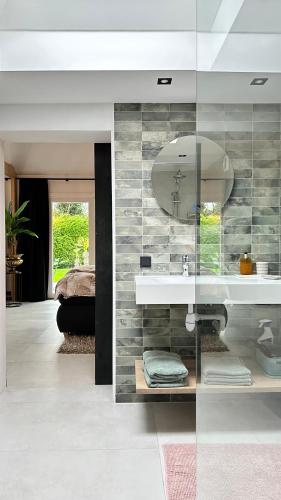 a bathroom with a sink and a mirror at Slapen bij de Zeeuwse Lala in IJzendijke