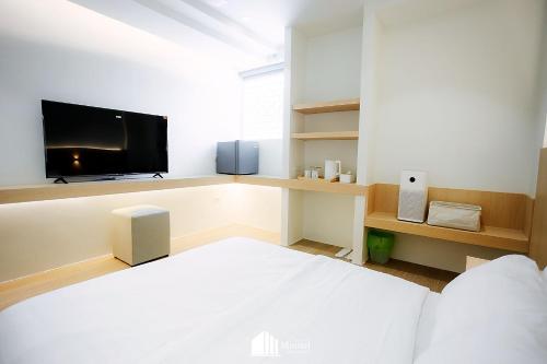 a bedroom with a bed and a flat screen tv at Minitel at Hatyai in Ban Khlong Wa