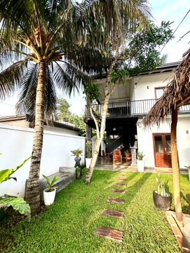 a backyard with palm trees and a house at Surf Heavens in Dickwella