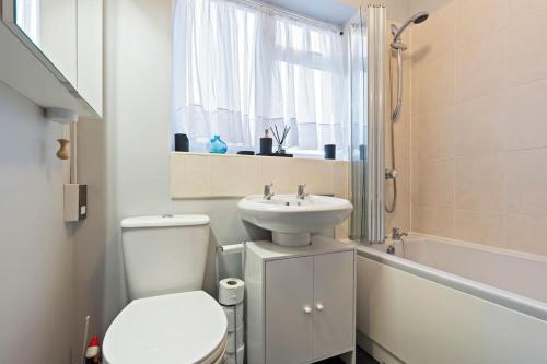 a white bathroom with a toilet and a sink at Perfect for Contractors Deal, 4BR House, 6BD, City Center, Free WiFi, Parking in Huntspill