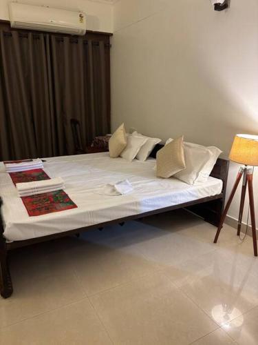 a bed with white sheets and pillows in a room at The Grand Ganga, Peaceful, Homely, Near Sangam in Prayagraj