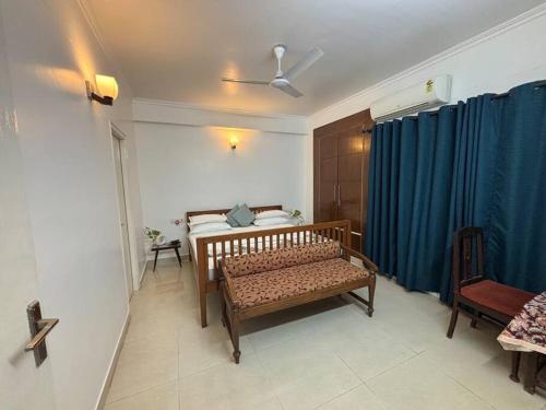 a bedroom with a bed and a blue curtain at The Grand Ganga, Peaceful, Homely, Near Sangam in Prayagraj