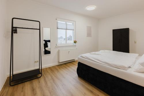 a bedroom with a large bed and a mirror at Das MONTI - Deluxe in Stendal