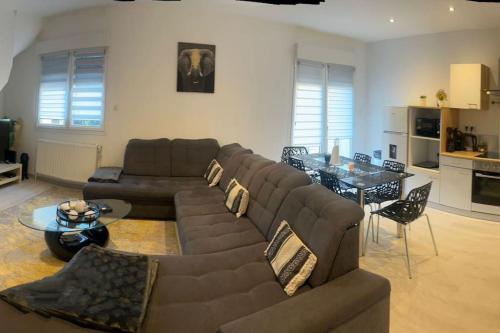 un salon avec un canapé marron et une table dans l'établissement Appartement cosy Nancy Bonsecours, à Jarville-la-Malgrange