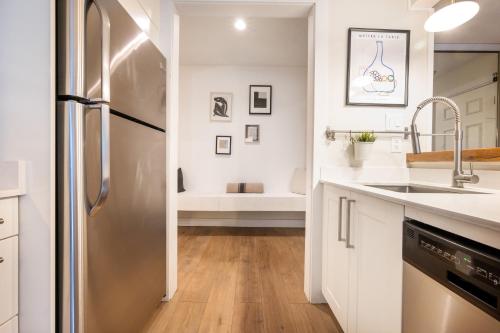 a kitchen with a stainless steel refrigerator and a sink at Creekside Oasis 4 Beds Pool and Hot Tub in Whistler