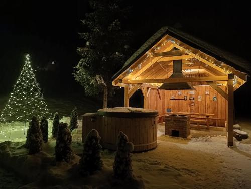 a wooden cabin in the snow with a christmas tree at Beskidzka Stodoła przy szlaku z pięknym widokiem in Złatna