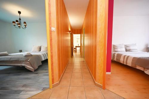 a hallway leading to two beds in a room at La Villa Noyau Doux in Ampuis
