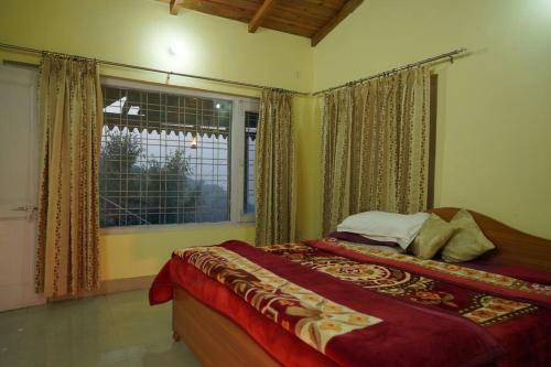 a bedroom with a bed and a large window at Dream Stay in Bhīm Tāl