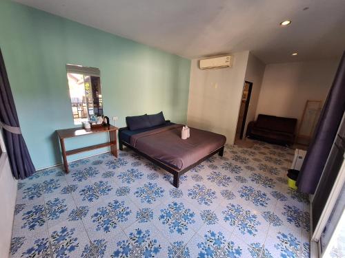 a bedroom with a bed and a table on a floor at Sleep Pai Bed & Breakfast in Pai