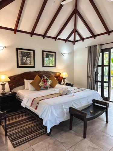 a bedroom with a large bed in a room at Hotel Chateau St Cloud in La Digue
