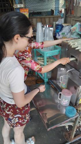 a woman is preparing food in a kitchen at Onsen Cóc Retreat in My Tho