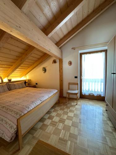 una camera da letto con un letto grande e una grande finestra di Villa Rosa a Vigo di Fassa