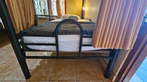 a small bed in a room with two windows at Mai Family Guest House in Singaraja